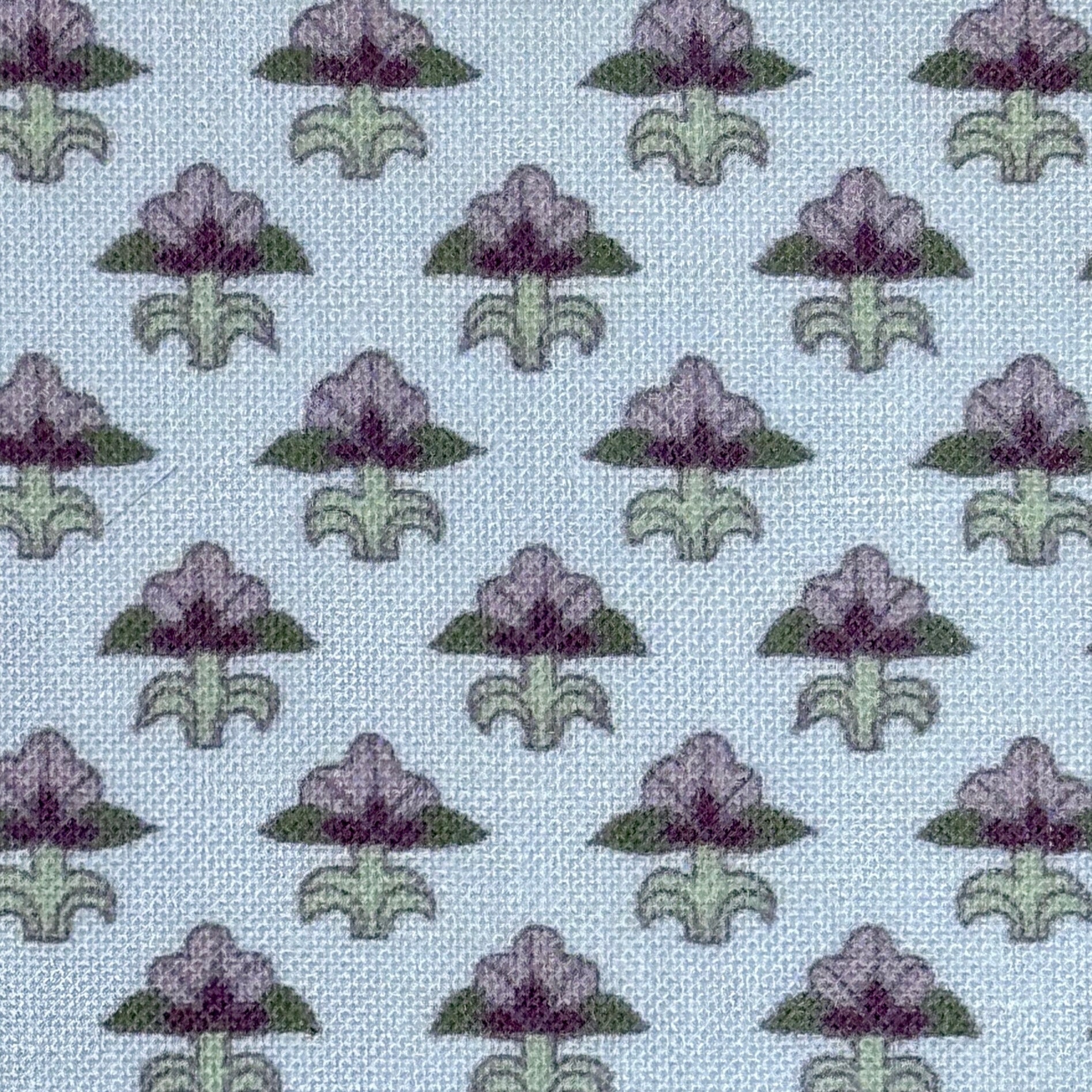 Pattern of purple and green floral designs on a light blue background