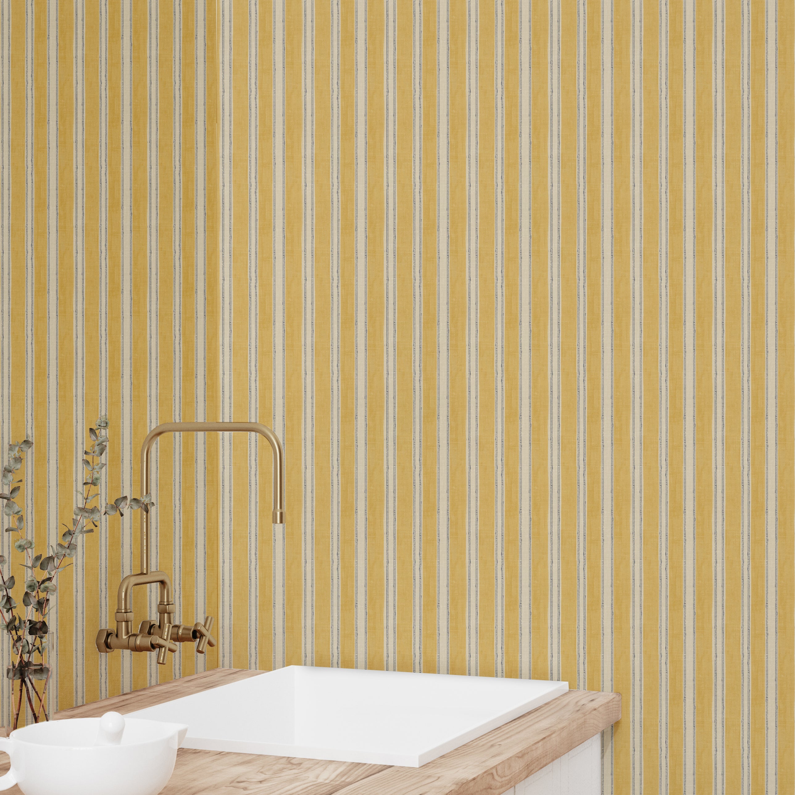 Bathroom with yellow striped wallpaper, white sink, and gold faucet.