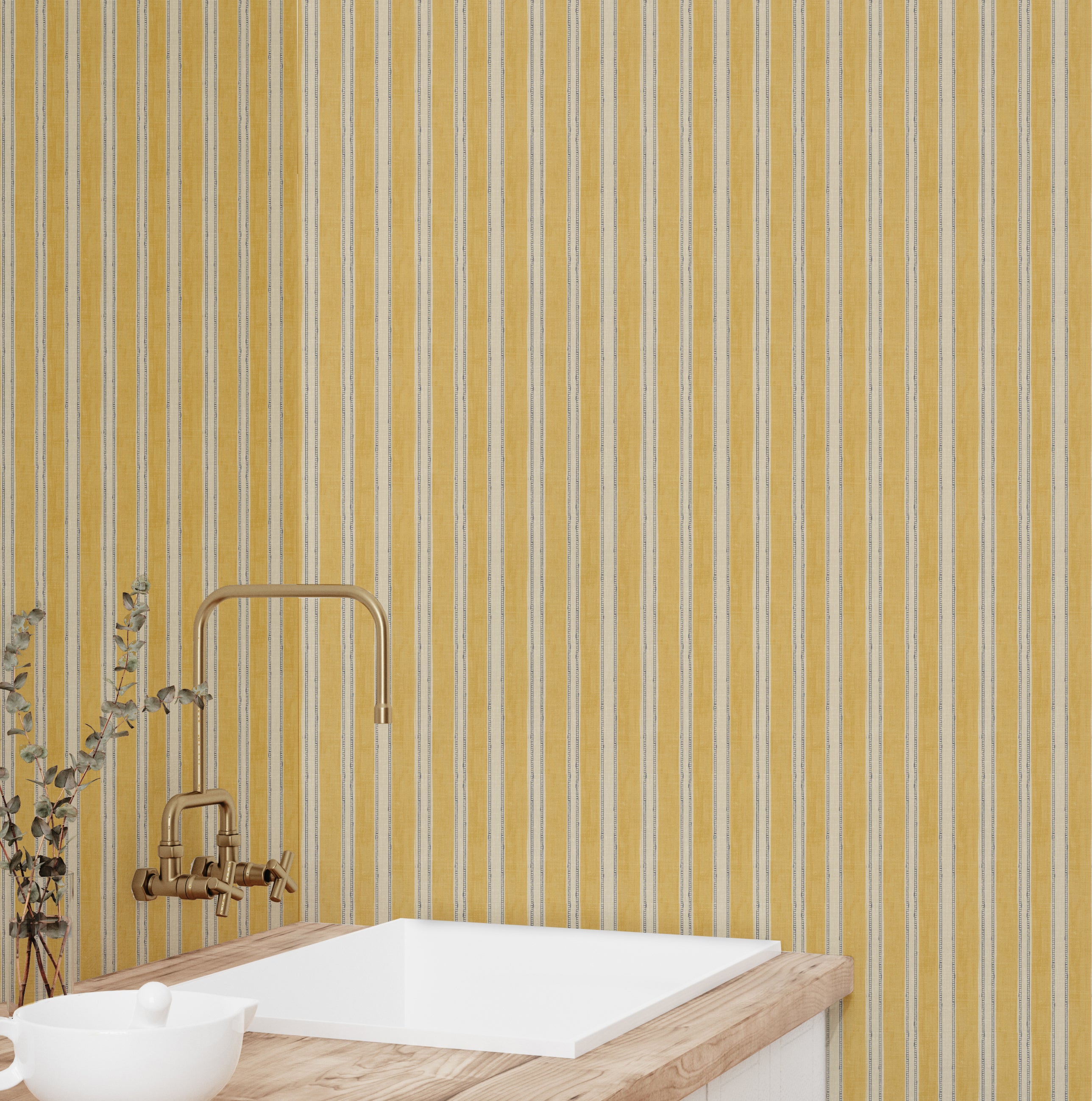 Bathroom with yellow striped wallpaper, white sink, and gold faucet.