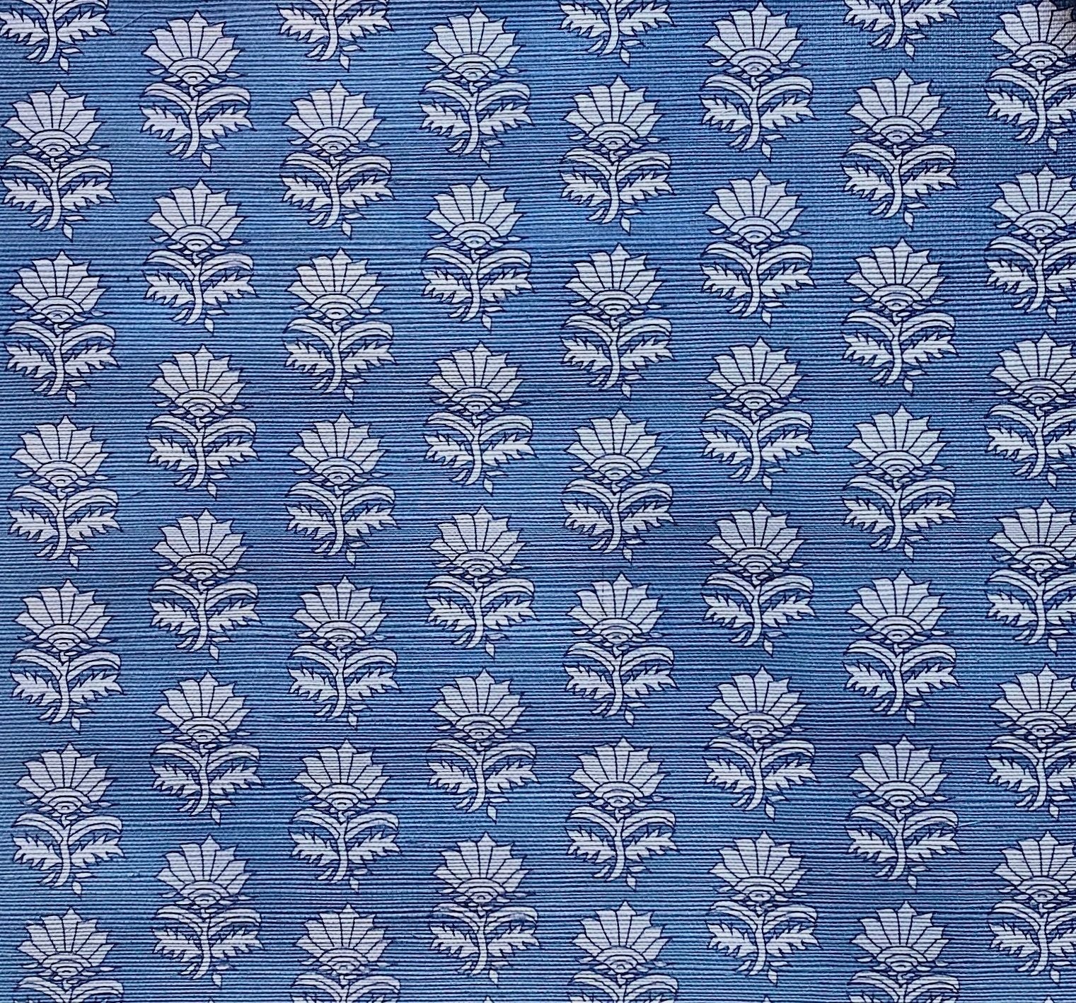 Detail of fabric in a repeating thistle print in navy and light blue on a blue field.
