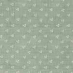 Detail of a linen fabric in a clustered dot pattern in cream on a sage field.