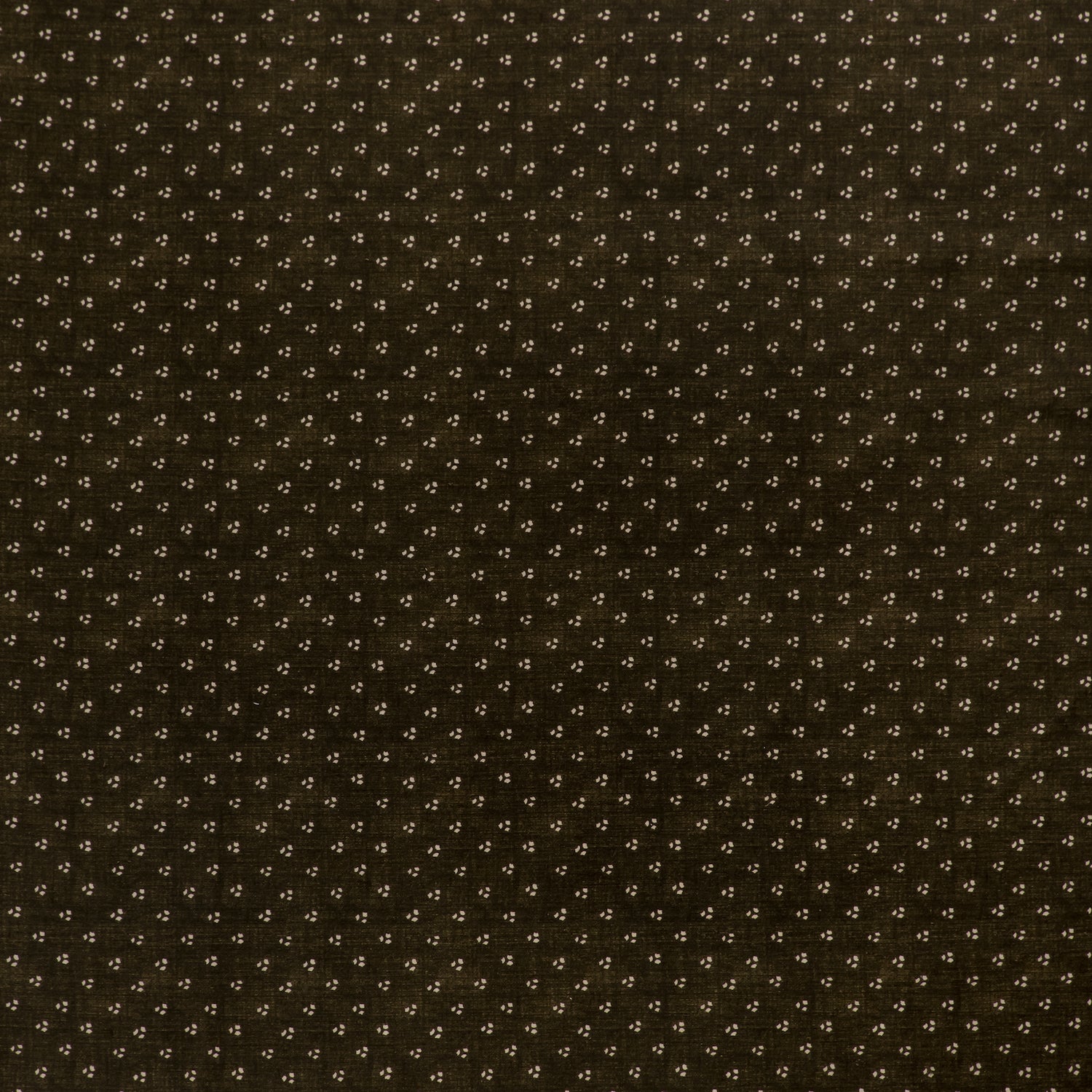 printed linen fabric in a clustered dot pattern in cream on a dark brown field.