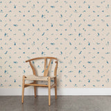 A wooden chair stands in front of a wall papered in a playful animal and branch print in blue on a cream field.