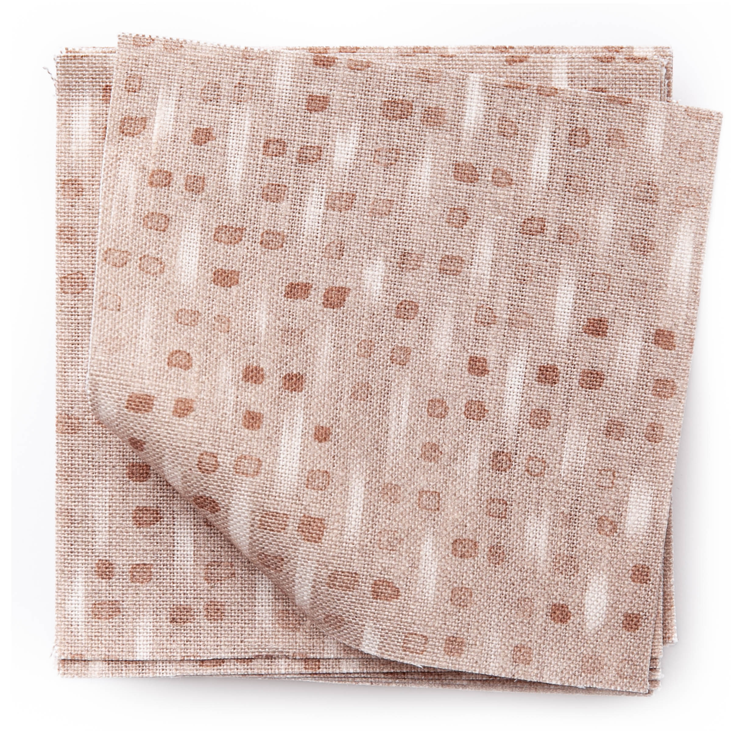 A stack of fabric swatches in a small-scale dot and dash pattern in shades of cream and pink on a light pink field.