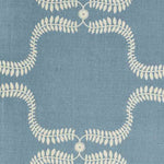 Detail of fabric in a leafy lattice print in cream on a blue field.