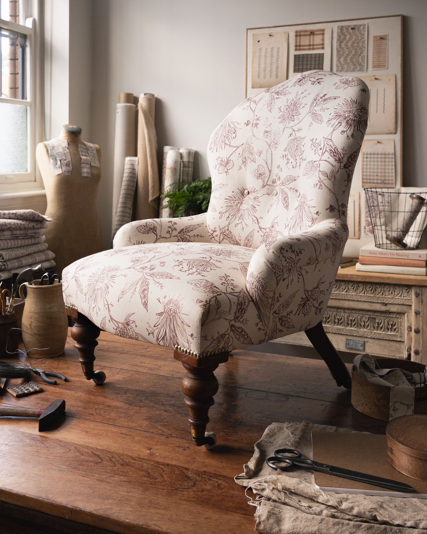 Upholstered antique chair in a purple floral design in a studio setting. 