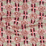 Draped fabric in a repeating floral print in shades of blue and white on a green grid print.