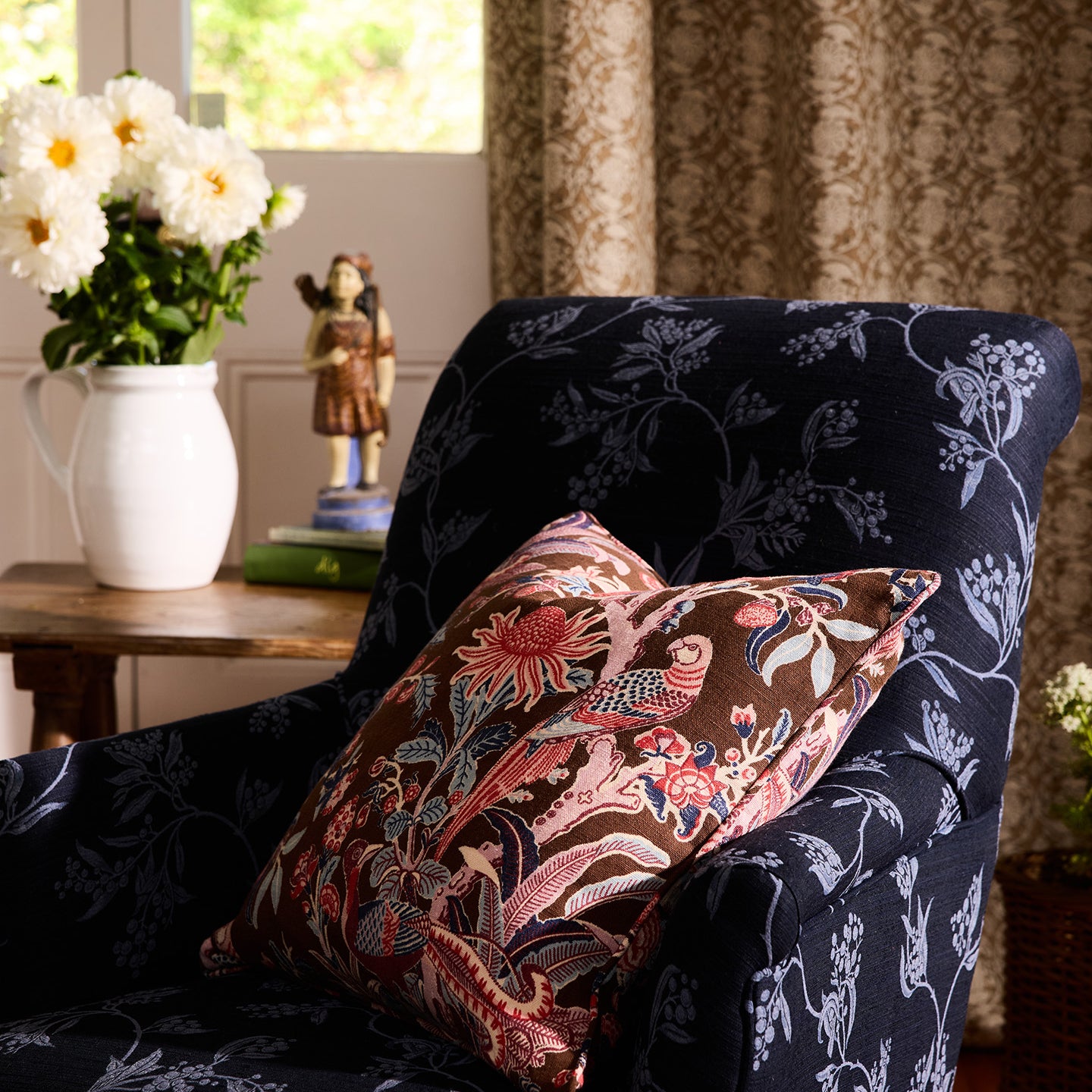 Navy armchair with floral-patterned cushions in a cozy room setting.