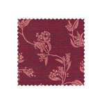 Fabric swatch on white of performance fabric with a scrolling floral design in magenta pink.