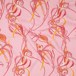 Draped fabric in a posy print in turquoise and white on a gray field.