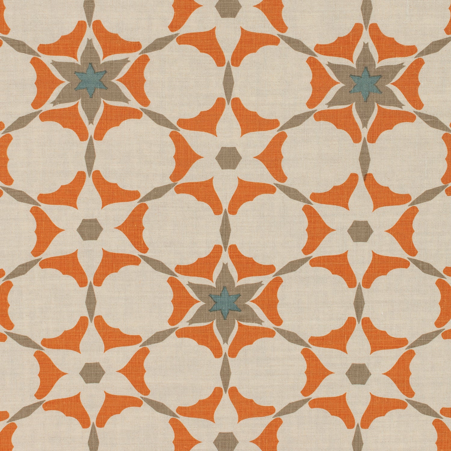 Detail of fabric in a geometric star print in shades of coral and brown on a tan field.
