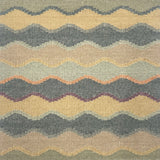Close-up of rug with wavy pattern in beige, turquoise, and orange.
