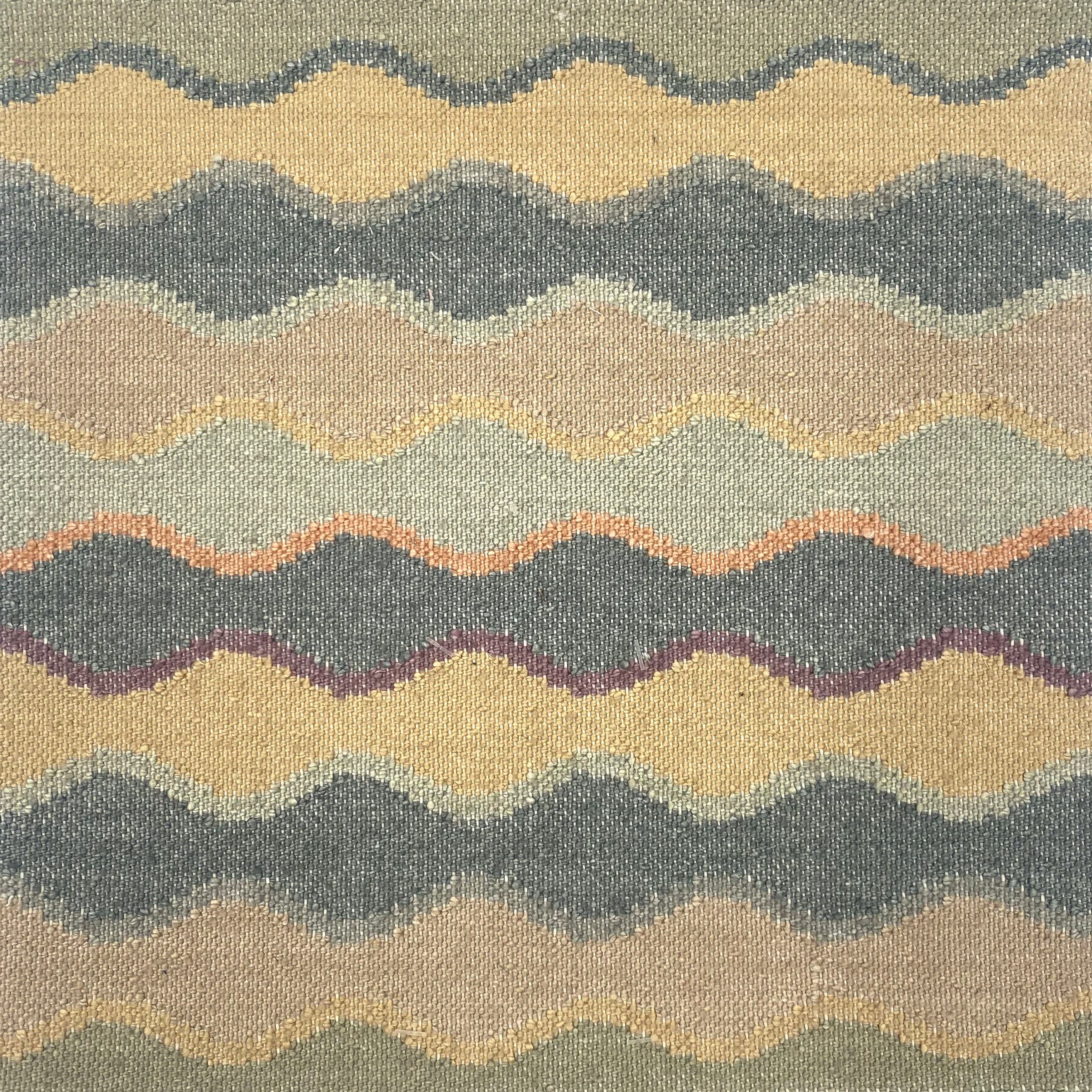 Close-up of rug with wavy pattern in beige, turquoise, and orange.