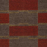 Detail of a handwoven carpet in a geometric design in brown, red with yellow accent. 