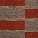 Detail of a handwoven carpet in a geometric design in brown, red with yellow accent. 