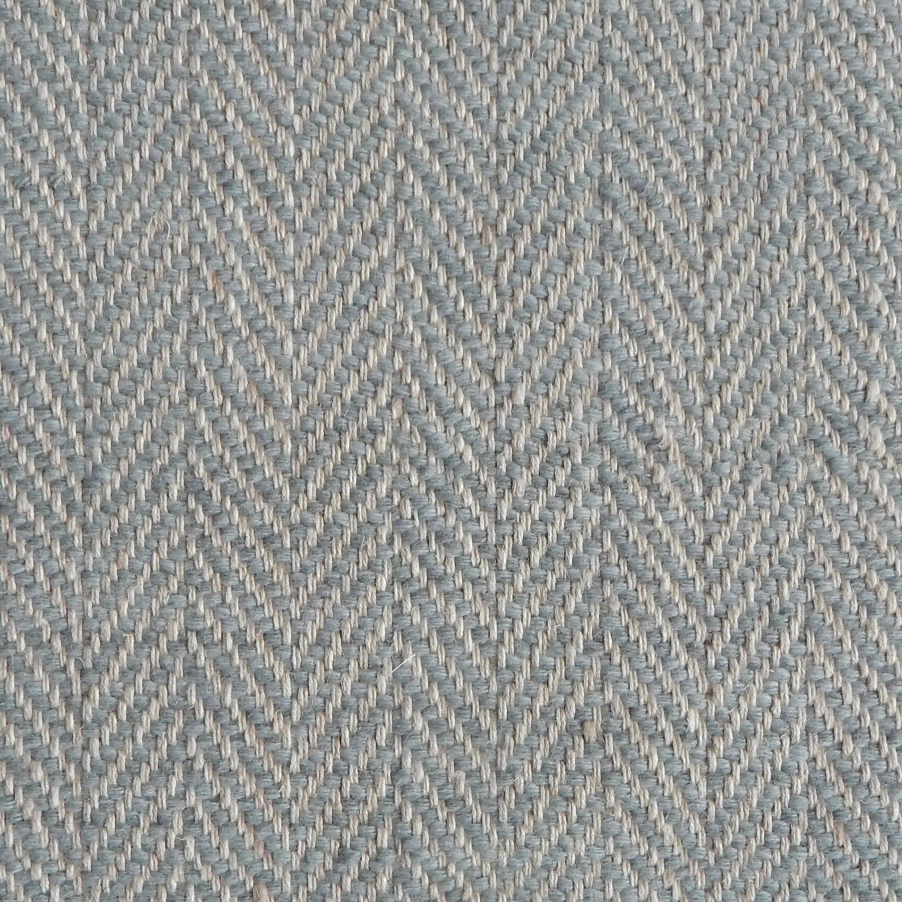 Close up of a rug in a woven herringbone pattern in grey-blue.