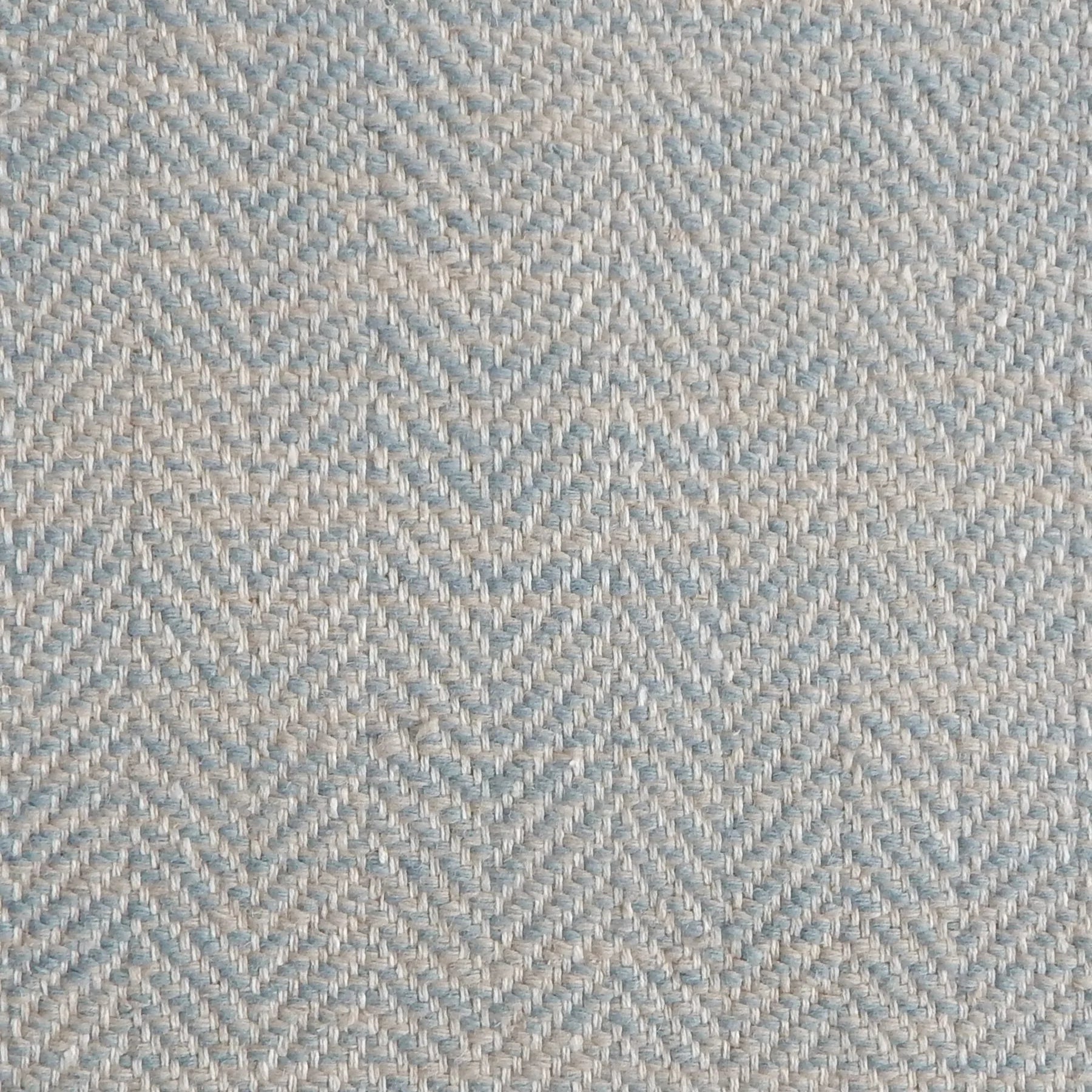 Close up of a rug in a woven herringbone pattern in light blue.