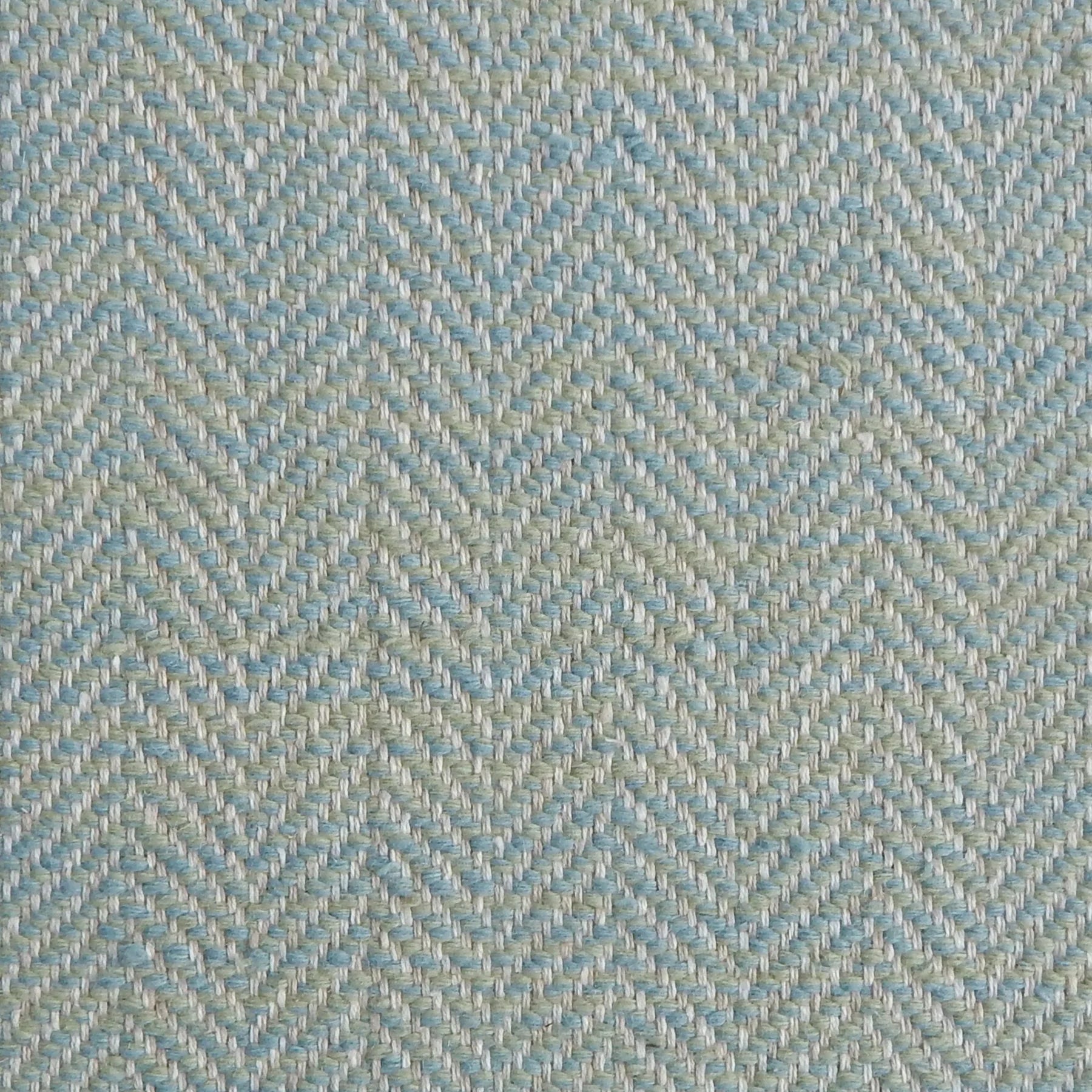 Close up of a rug in a woven herringbone pattern in aqua blue.