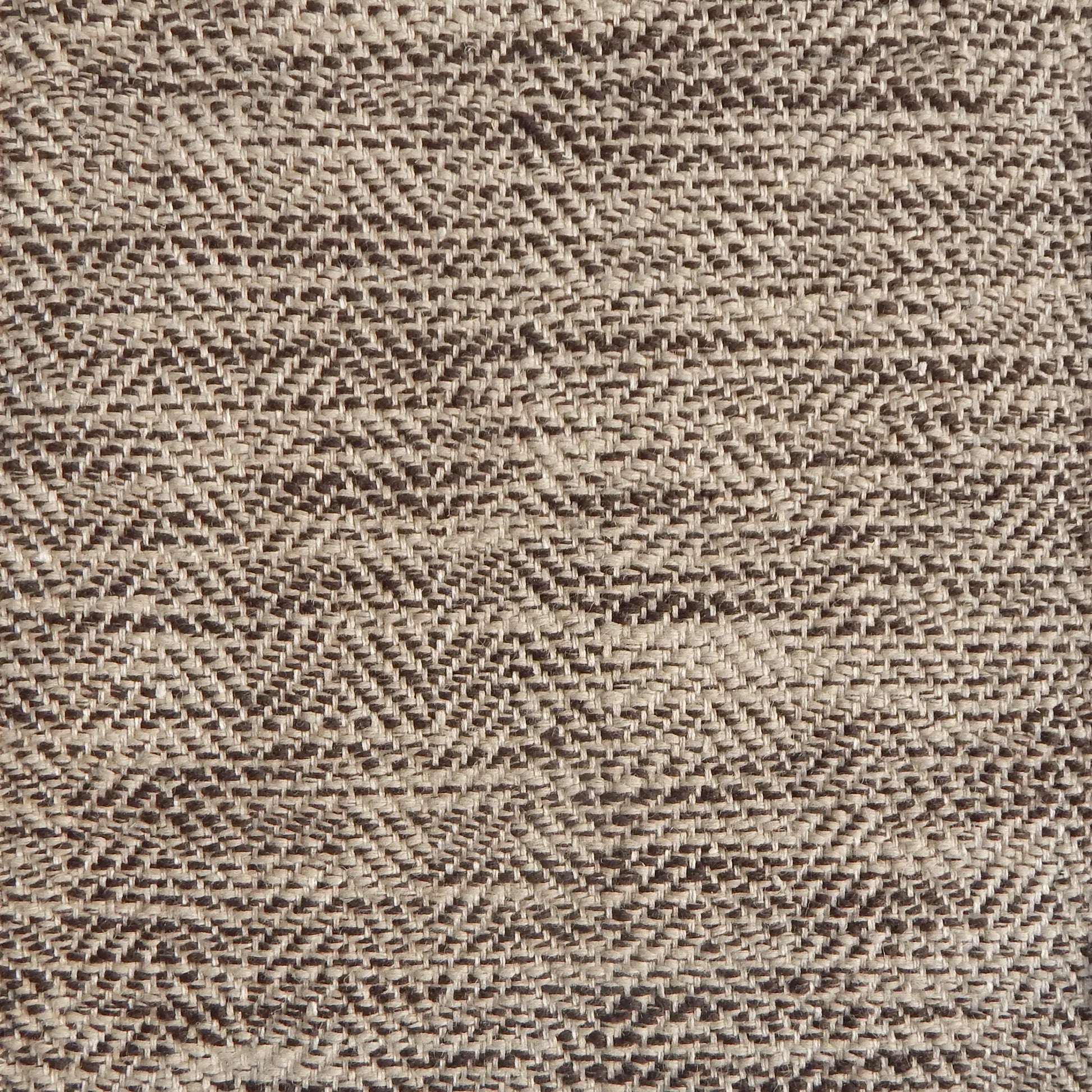 Close up of a rug in a woven herringbone pattern in shades of brown.
