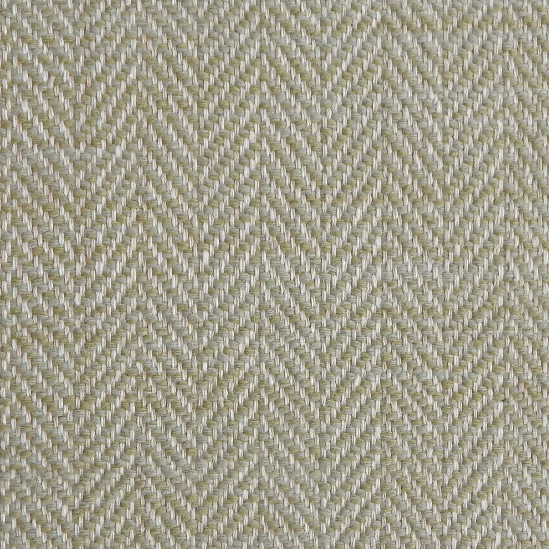 Close up of a rug in a woven herringbone pattern in light green.