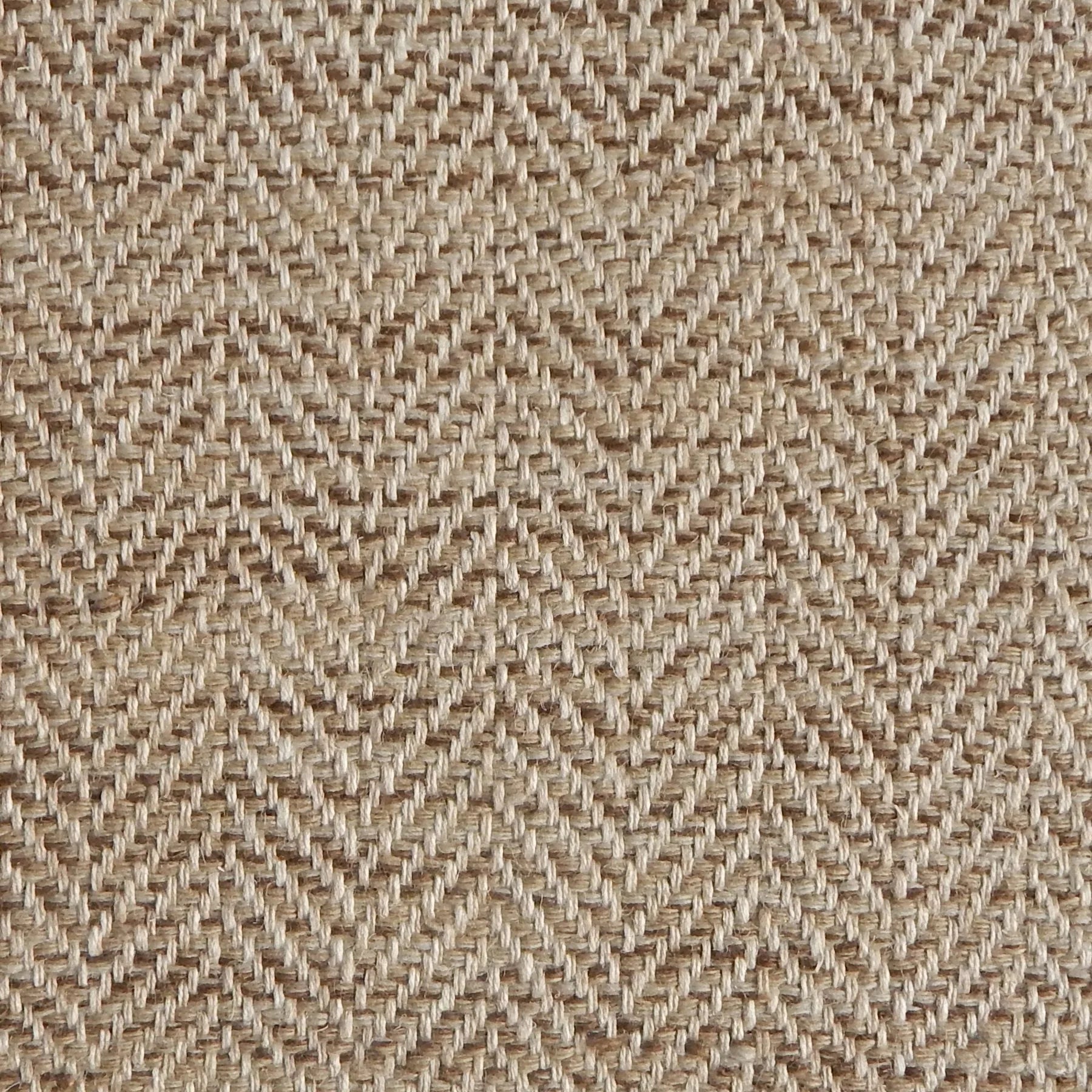 Close up of a rug in a woven herringbone pattern in brown.