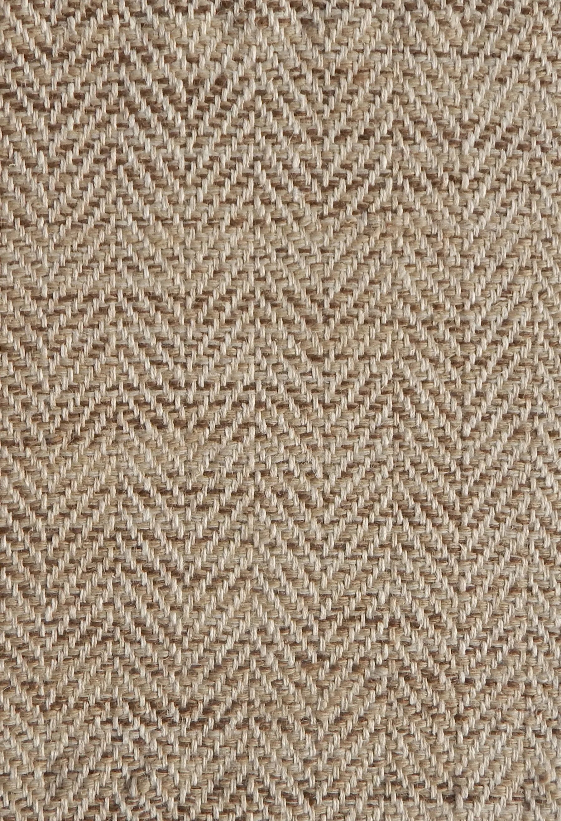 Close up of a rug in a woven herringbone pattern in brown.
