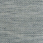 Close up of a rug in a woven herringbone pattern in shades of blue.
