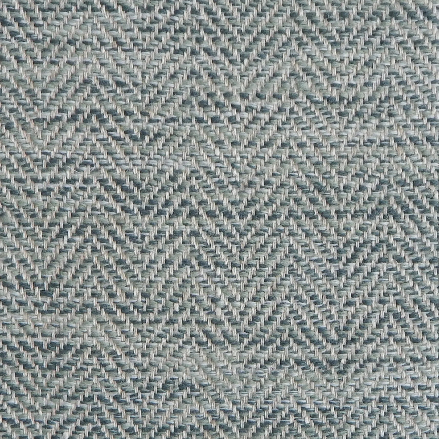 Close up of a rug in a woven herringbone pattern in shades of blue.