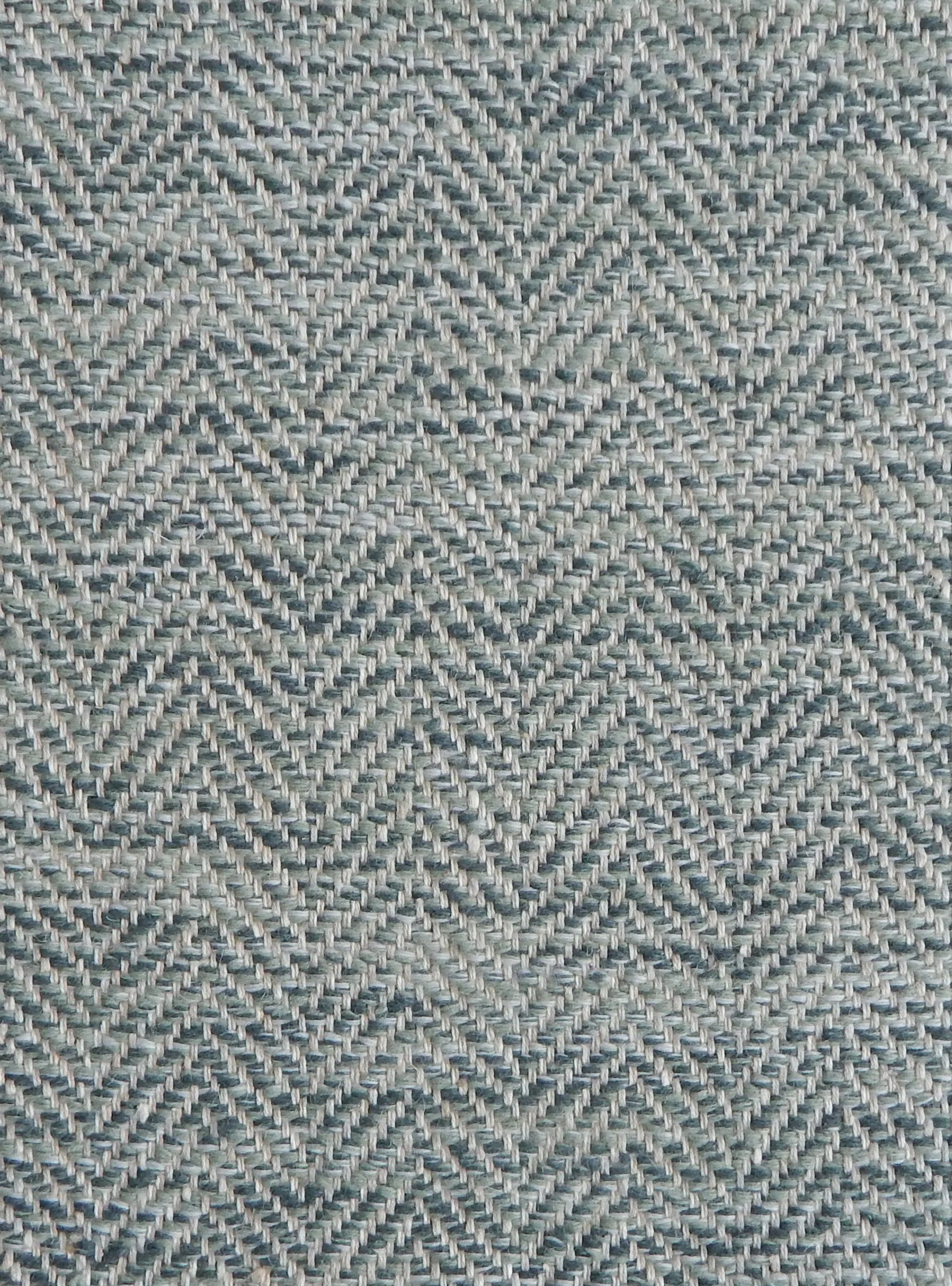 Close up of a rug in a woven herringbone pattern in shades of blue.
