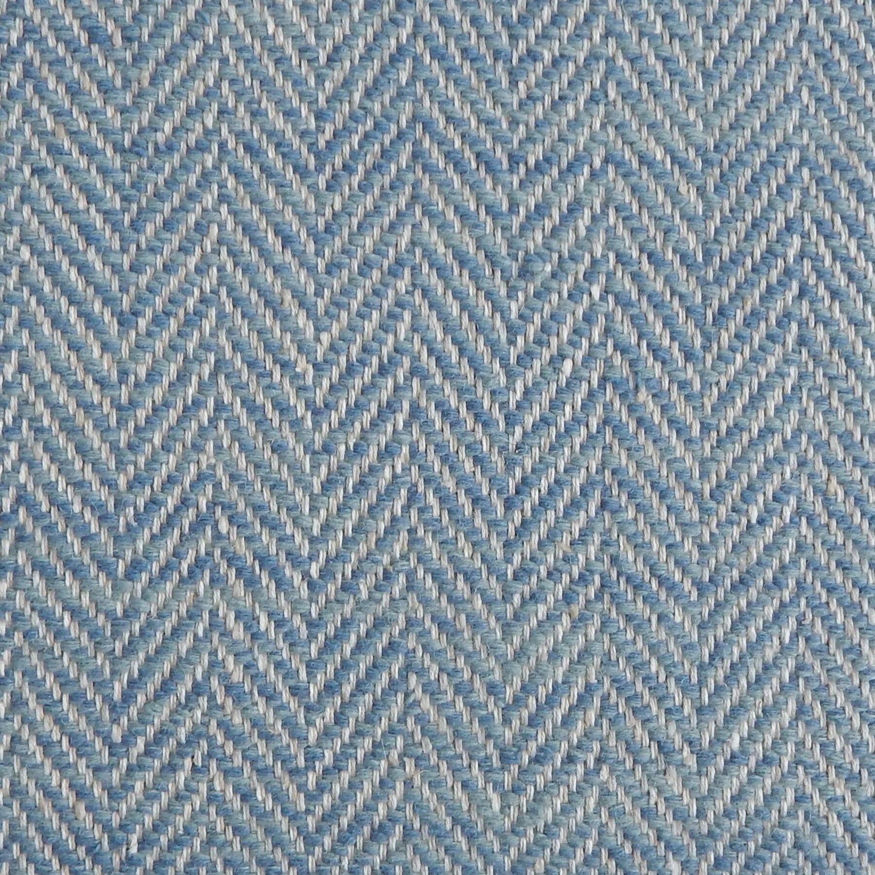 Close up of a rug in a woven herringbone pattern in blue.