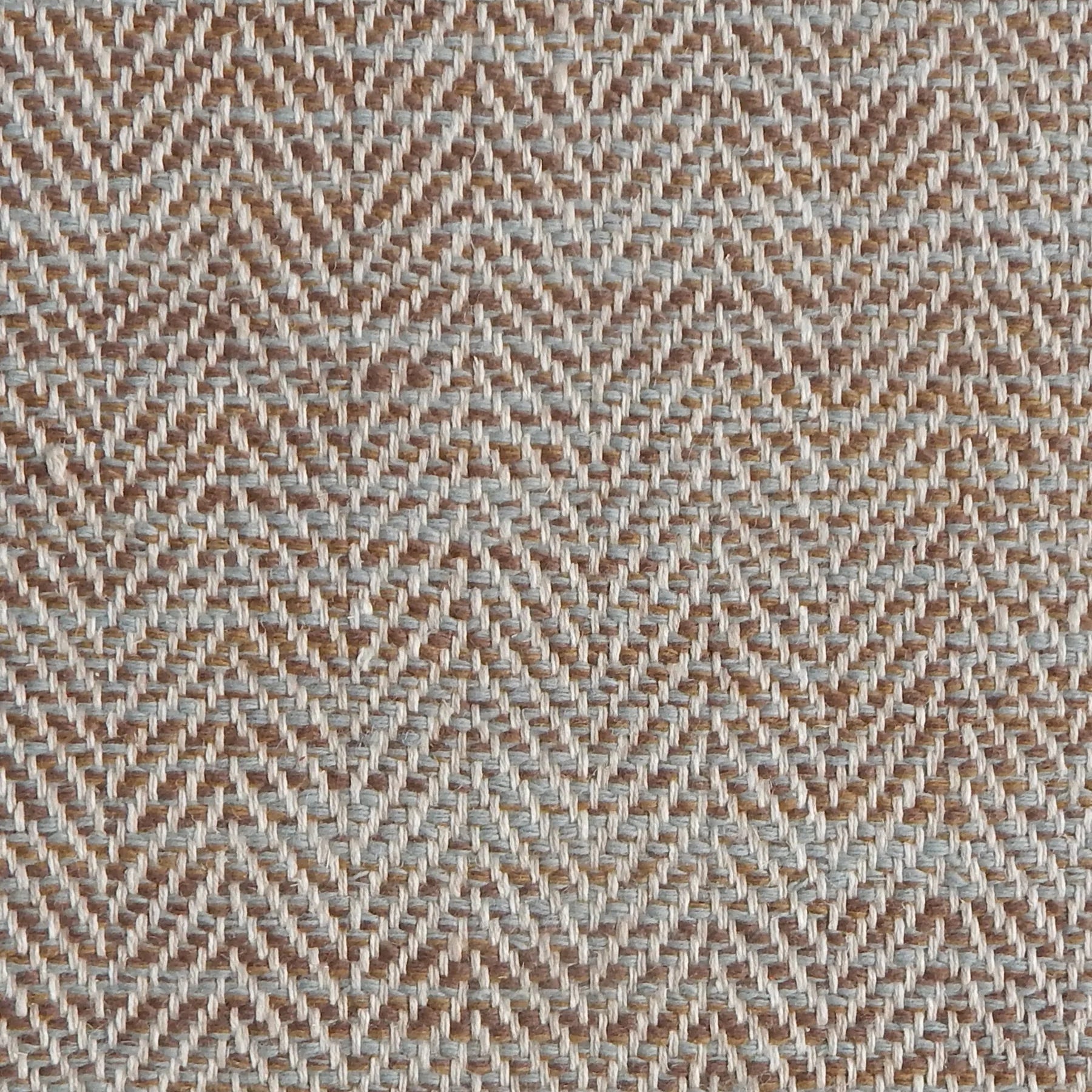 Close up of a rug in a woven herringbone pattern in blue and brown. 