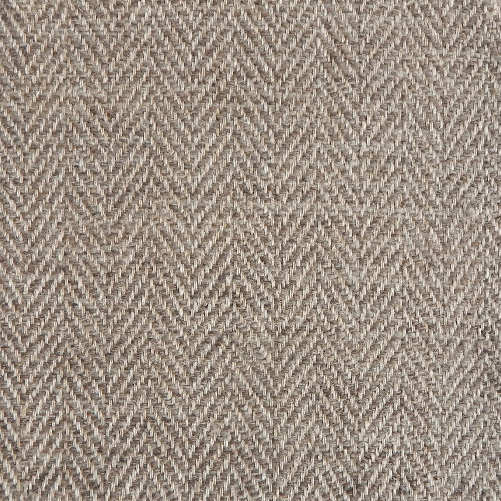 Close up of a rug in a woven herringbone pattern in taupe.