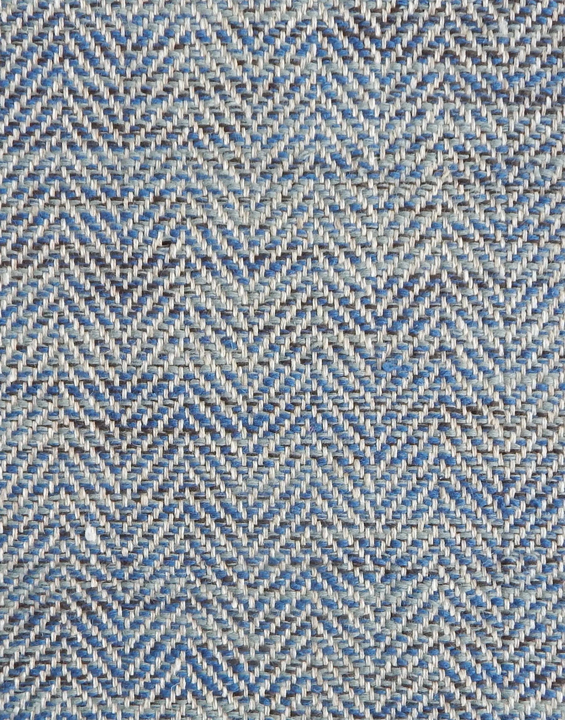 Close up of a rug in a woven herringbone pattern in blues.