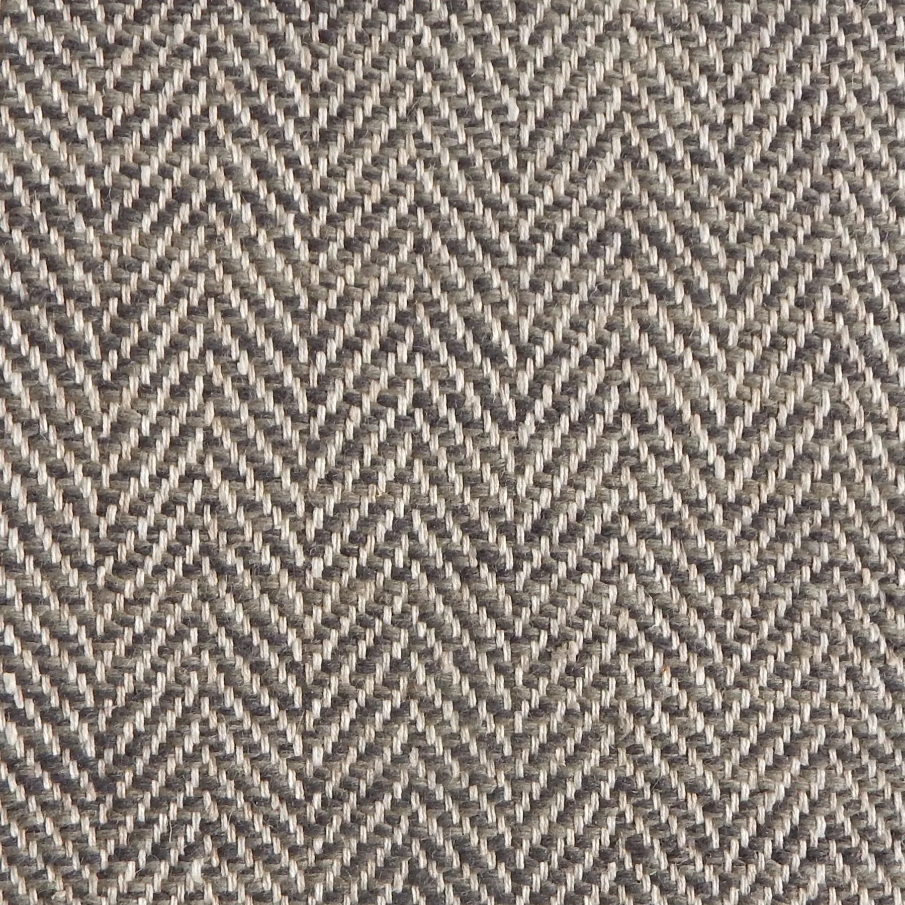 Close up of a rug in a woven herringbone pattern in grey and brown.