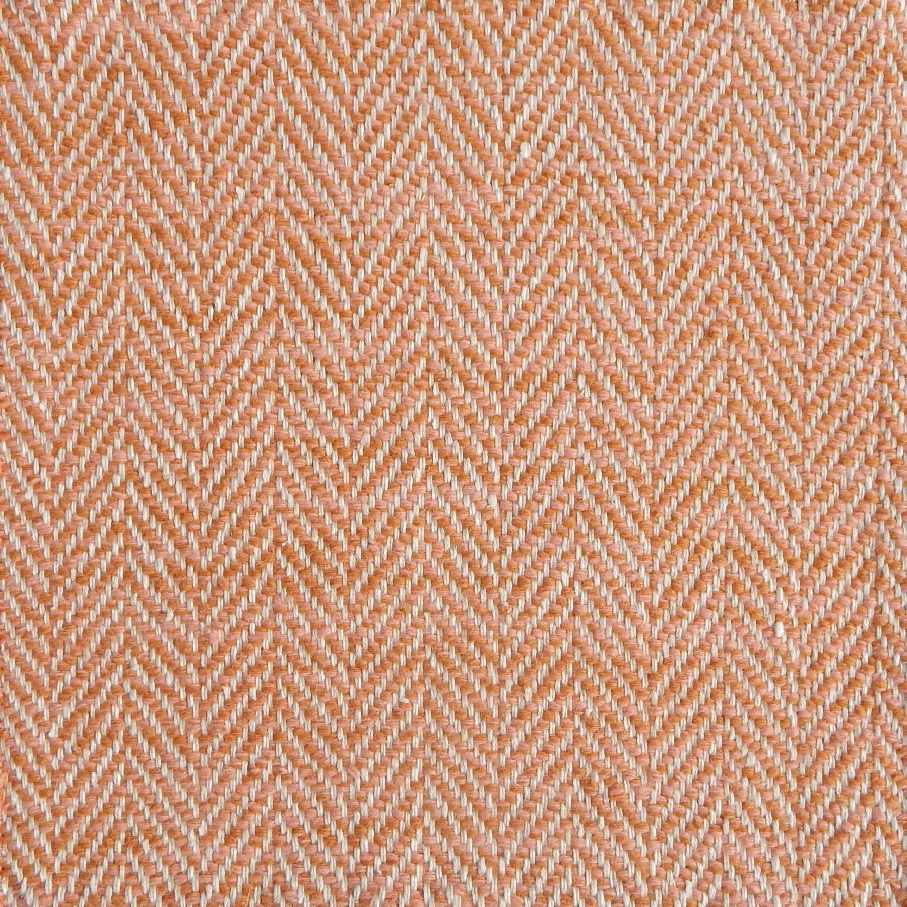 Close up of a rug in a woven herringbone pattern in orange.
