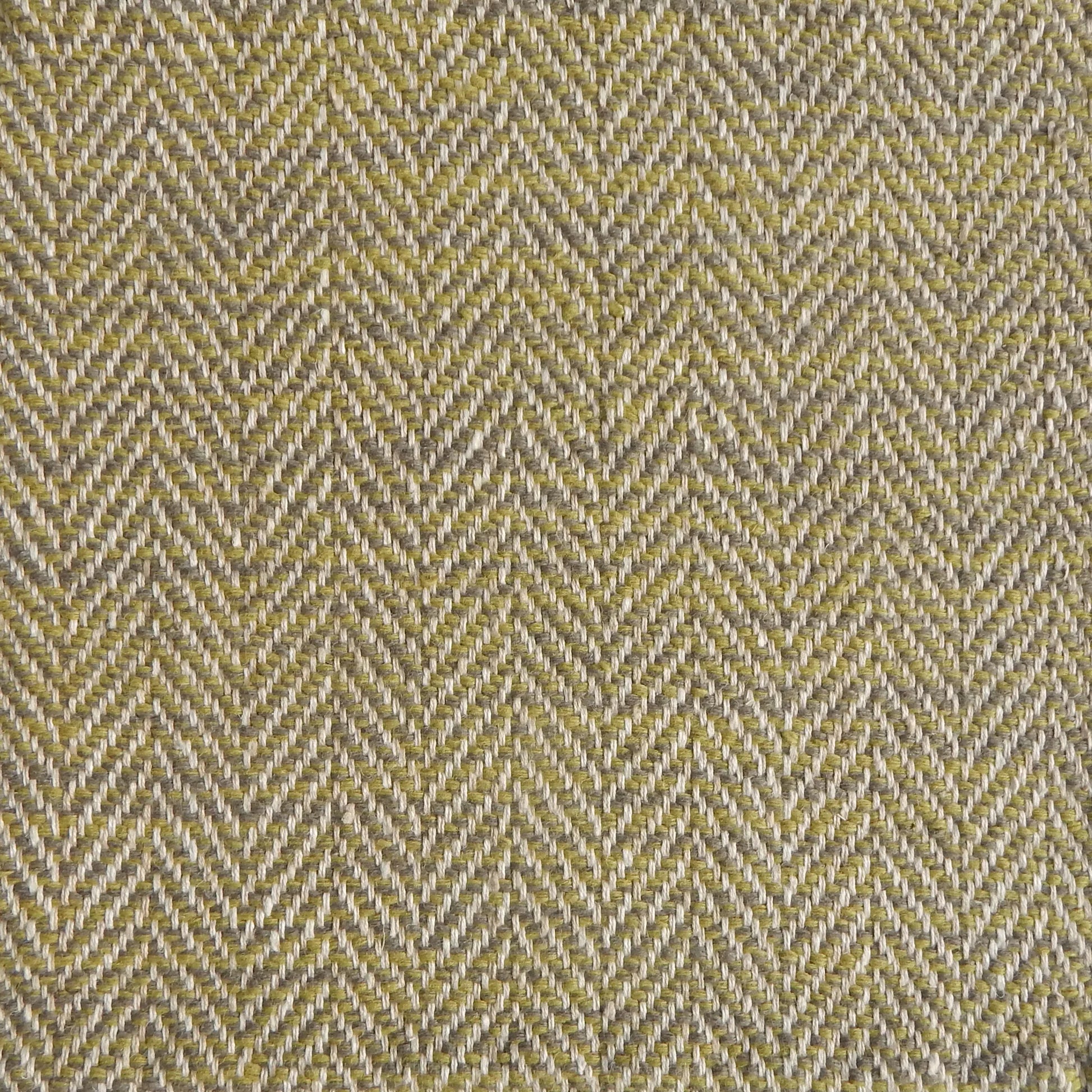 Close up of a rug in a woven herringbone pattern in bright green.