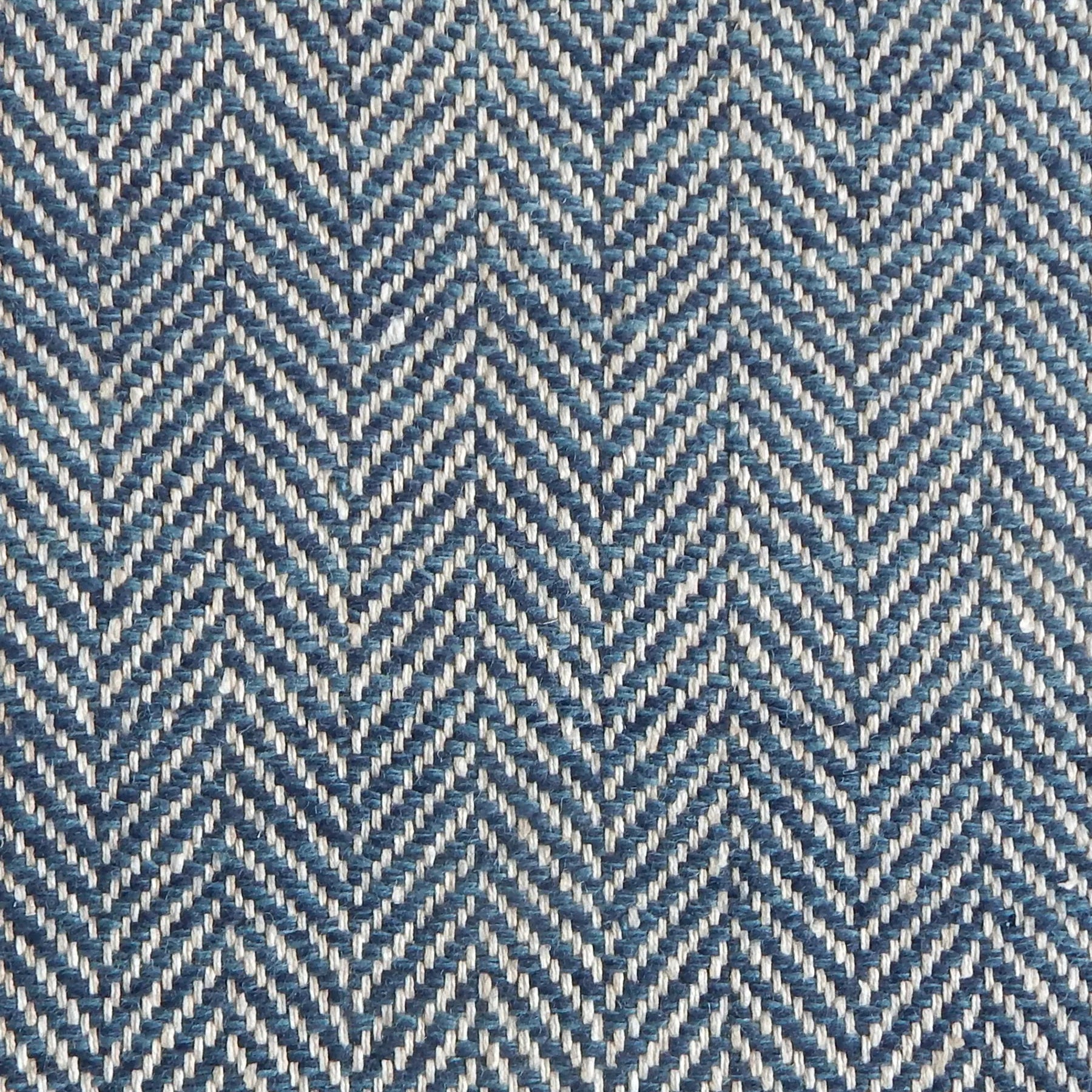 Close up of a rug in a woven herringbone pattern in blue.