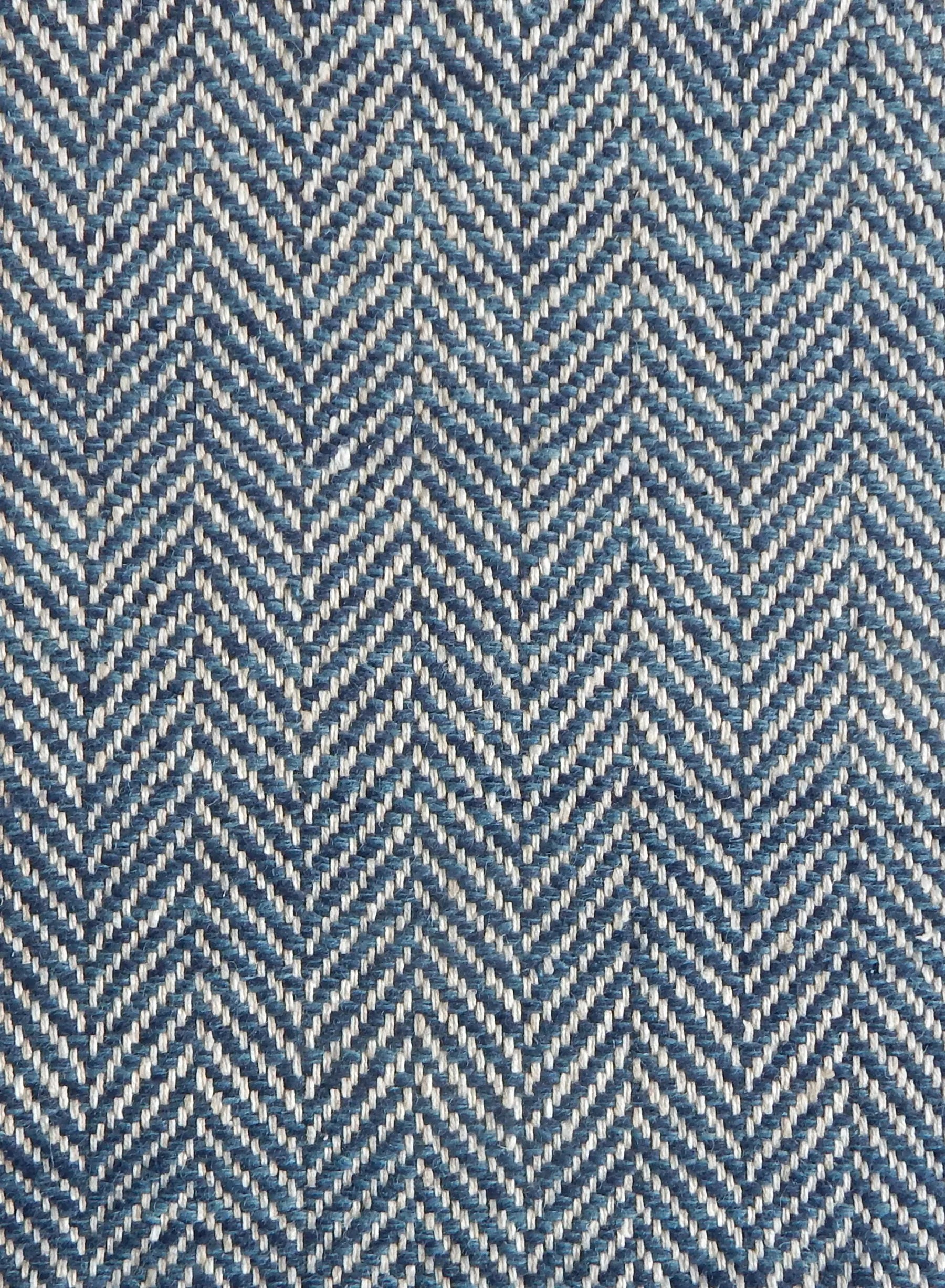 Close up of a rug in a woven herringbone pattern in blue.