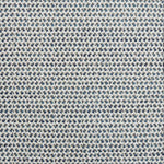 A handwoven rug with a herringbone weave in white with striated yarns of dark grey and marine blue.