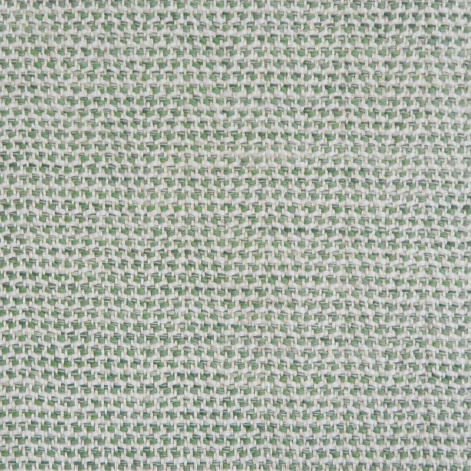A handwoven rug with a herringbone weave in white with striated yarns in shades of light green.