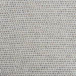 A handwoven rug with a herringbone weave in white with striated yarns in shades of grey.