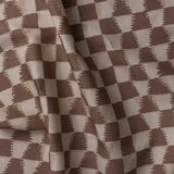 Detail of gently draped printed fabric in a watercolor ikat-inspired checkerboard pattern in tonal warm clay brown. 