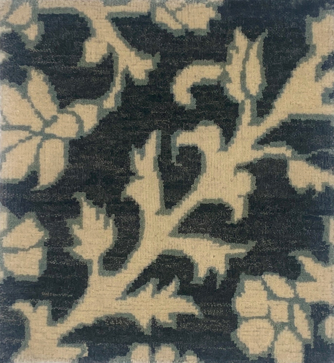 Close-up of a handknotted rug in afloral paisley in cream on a charcoal field