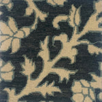 Close-up of a handknotted rug in afloral paisley in cream on a charcoal field