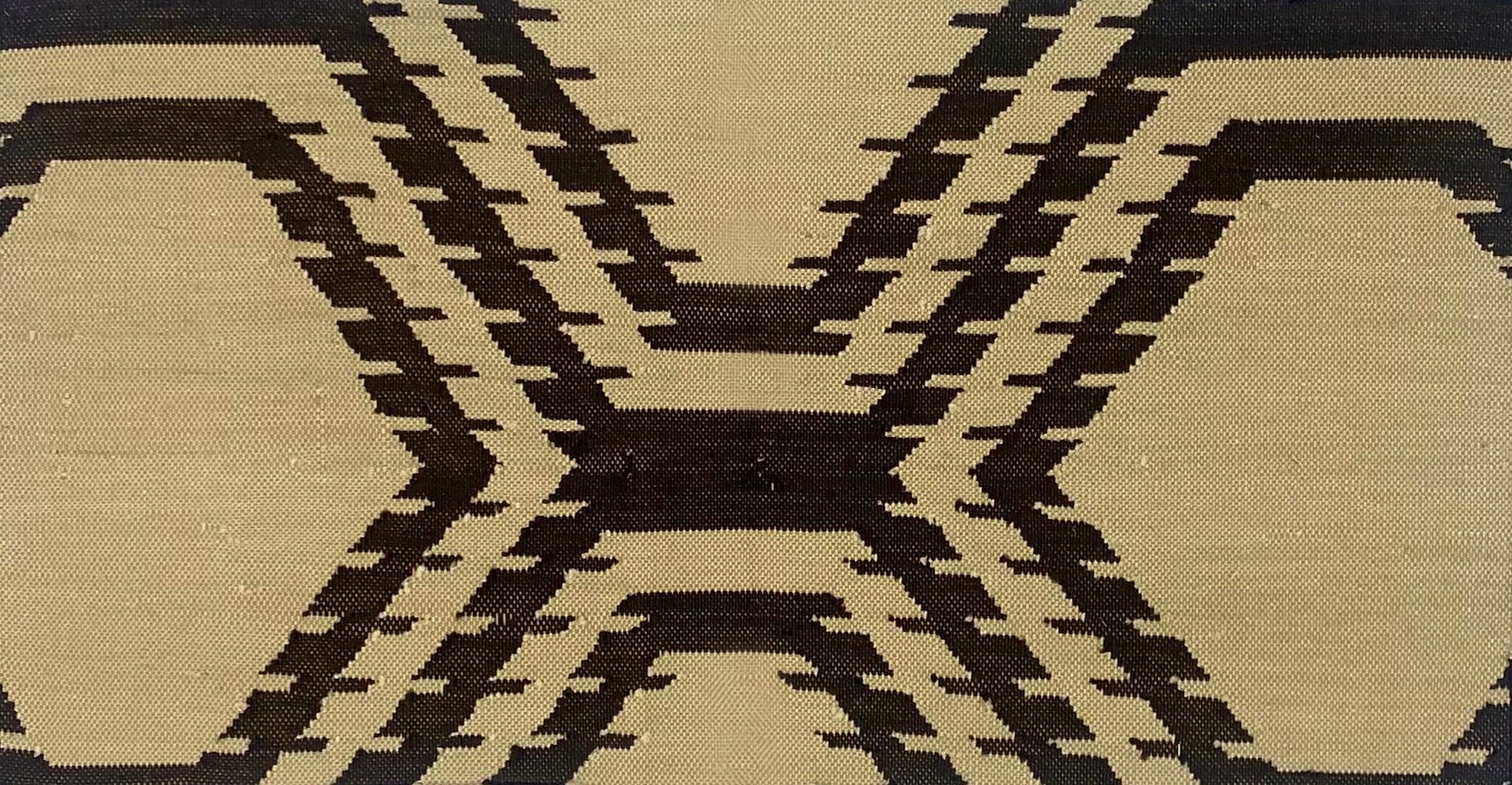 Handwoven rug with geometric pattern in black and beige