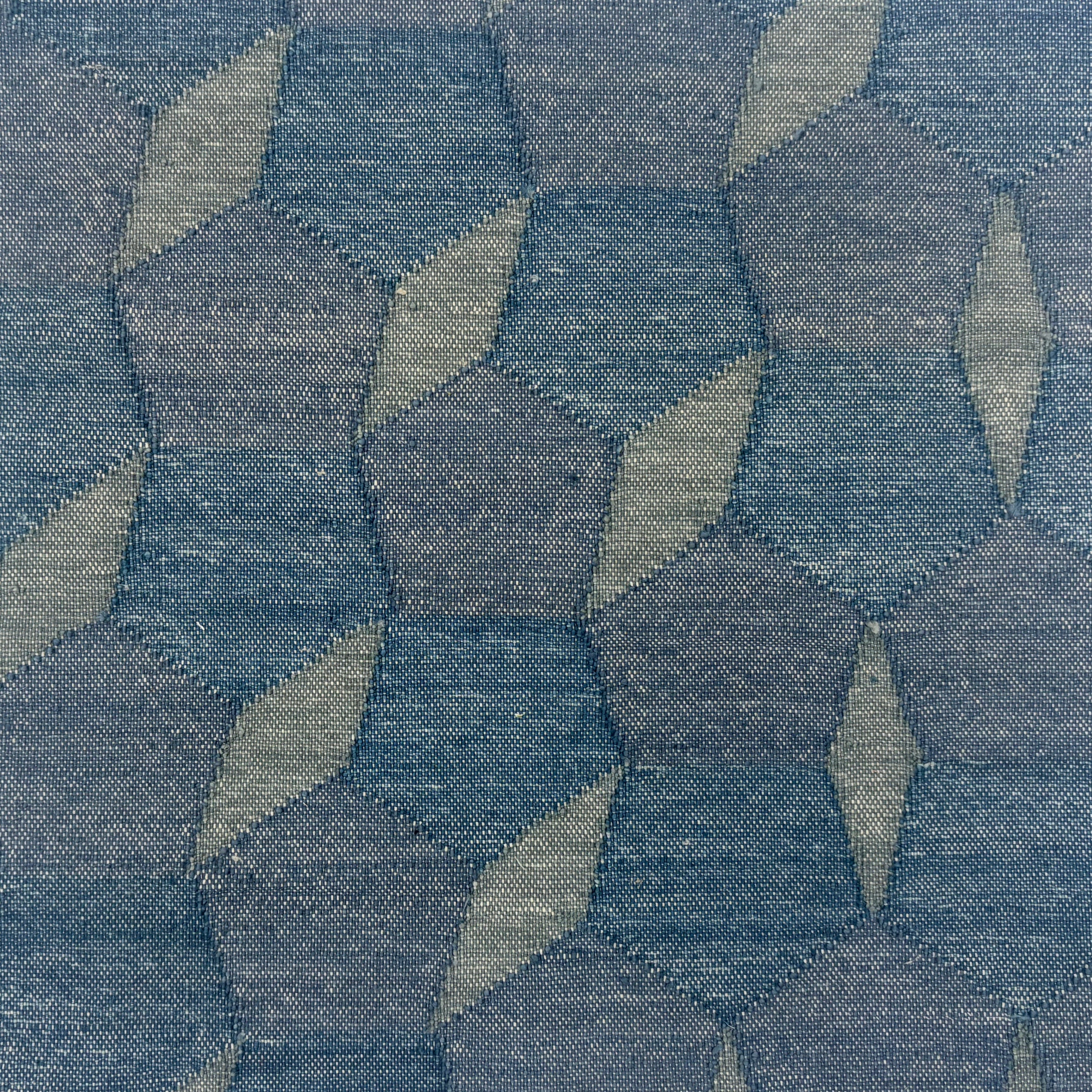 Handmade flatweave rug with a geometric mosaic design with pentagons and diamonds in tonal shades of blue.