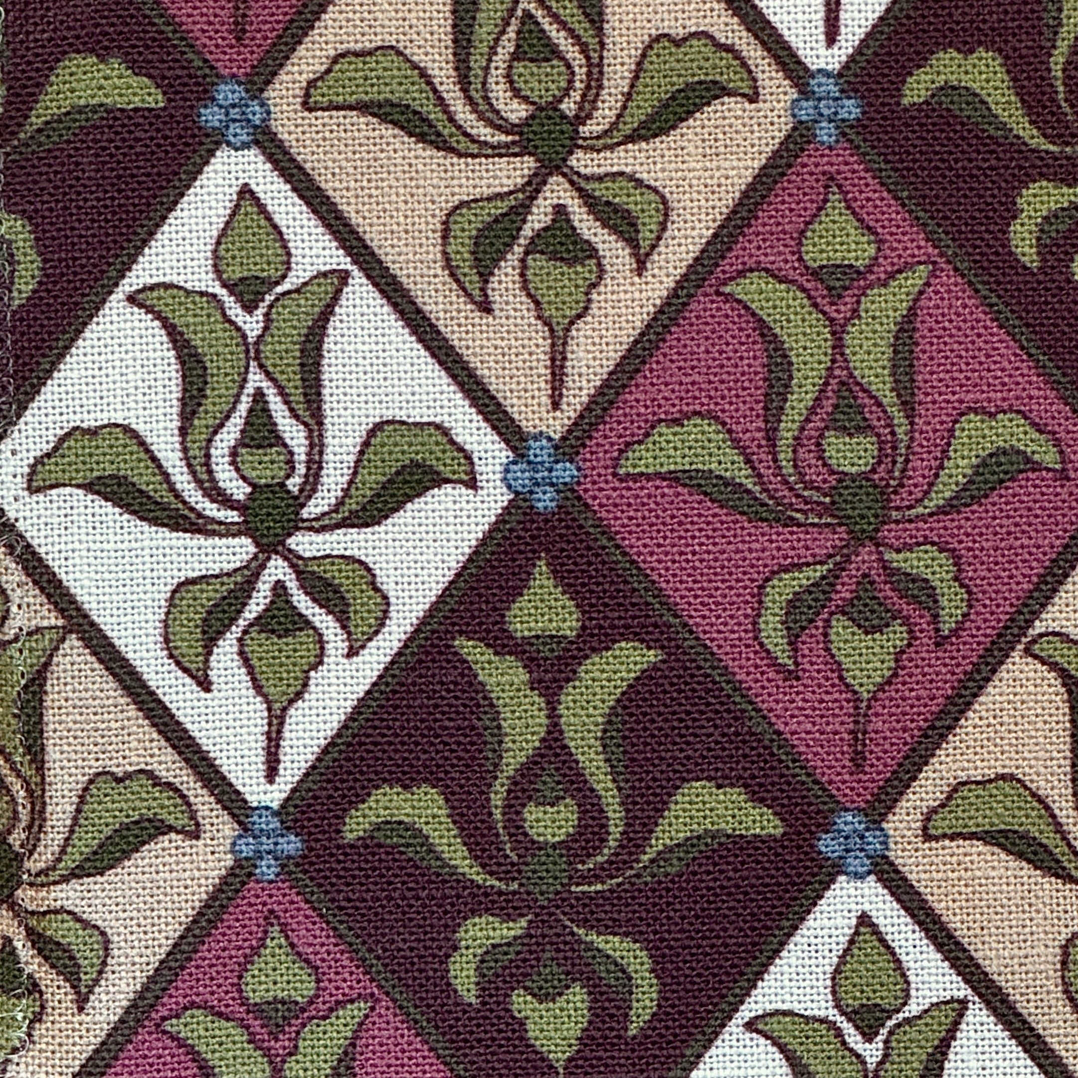 Patterned fabric with green and purple floral design in a lattice design. 
