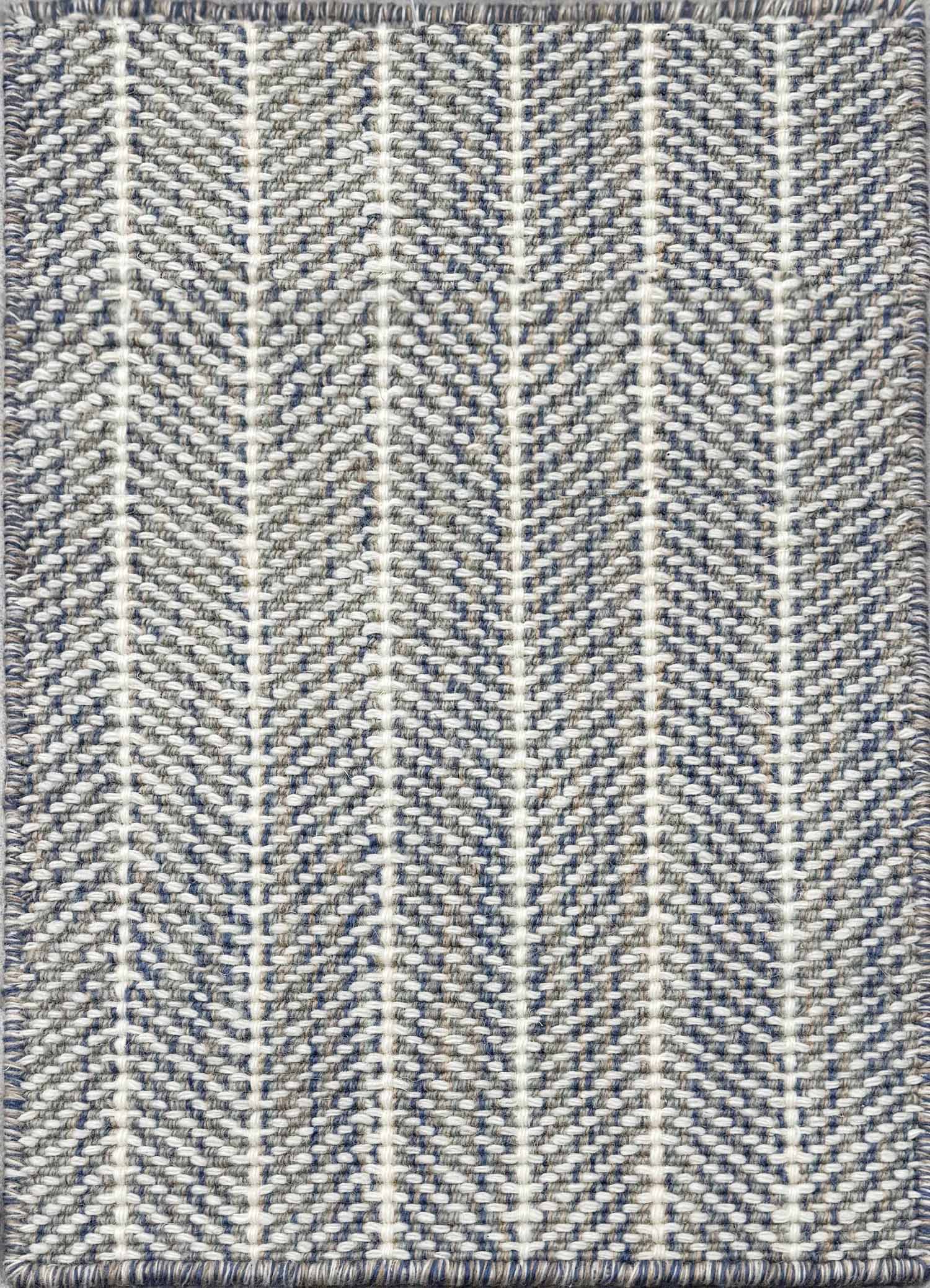 Close up of broadloom carpet with striated herringbone weave in white with accents of blue and brown.