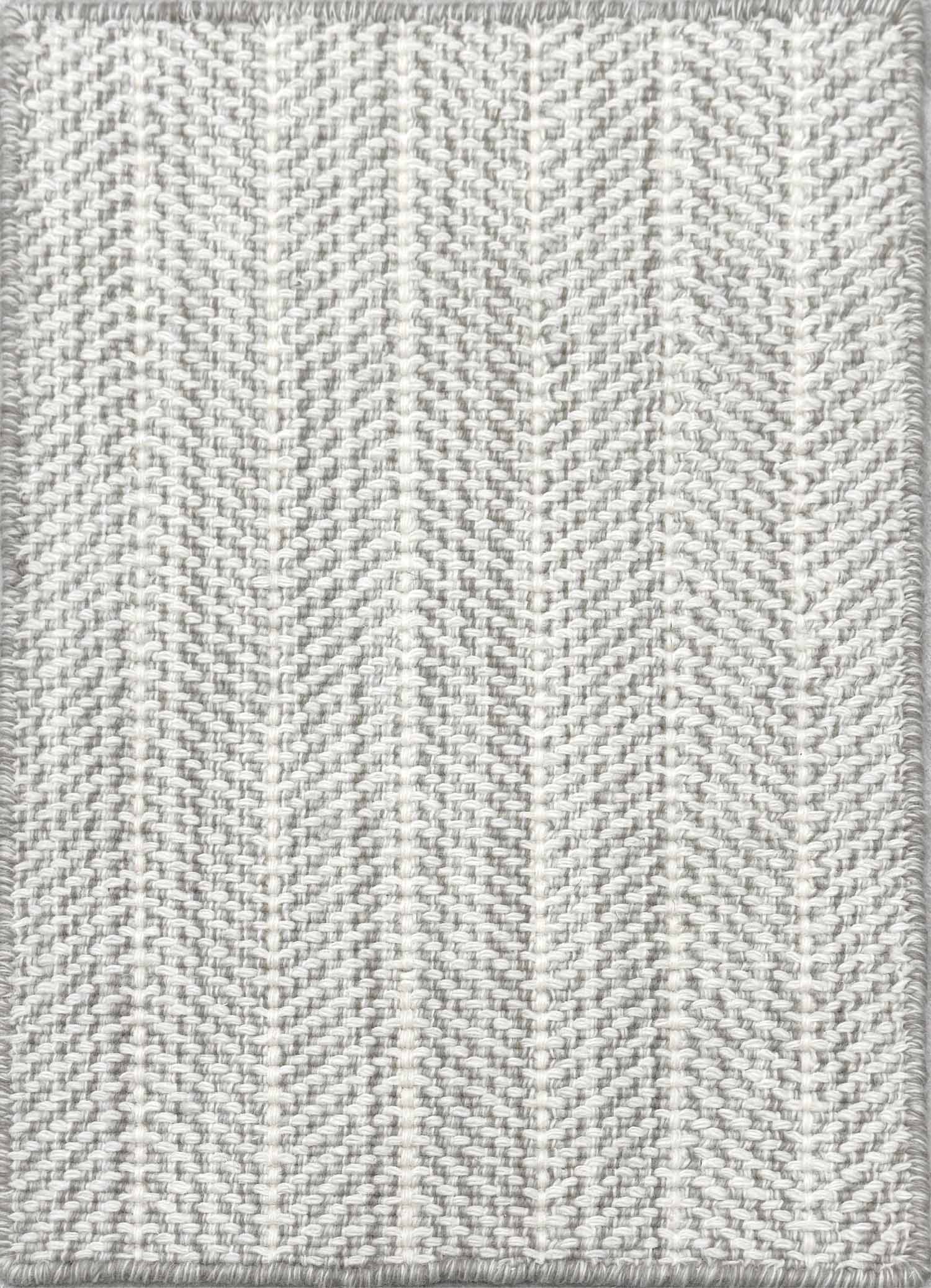 Close up of broadloom carpet with striated herringbone weave in white with accents of light grey.
