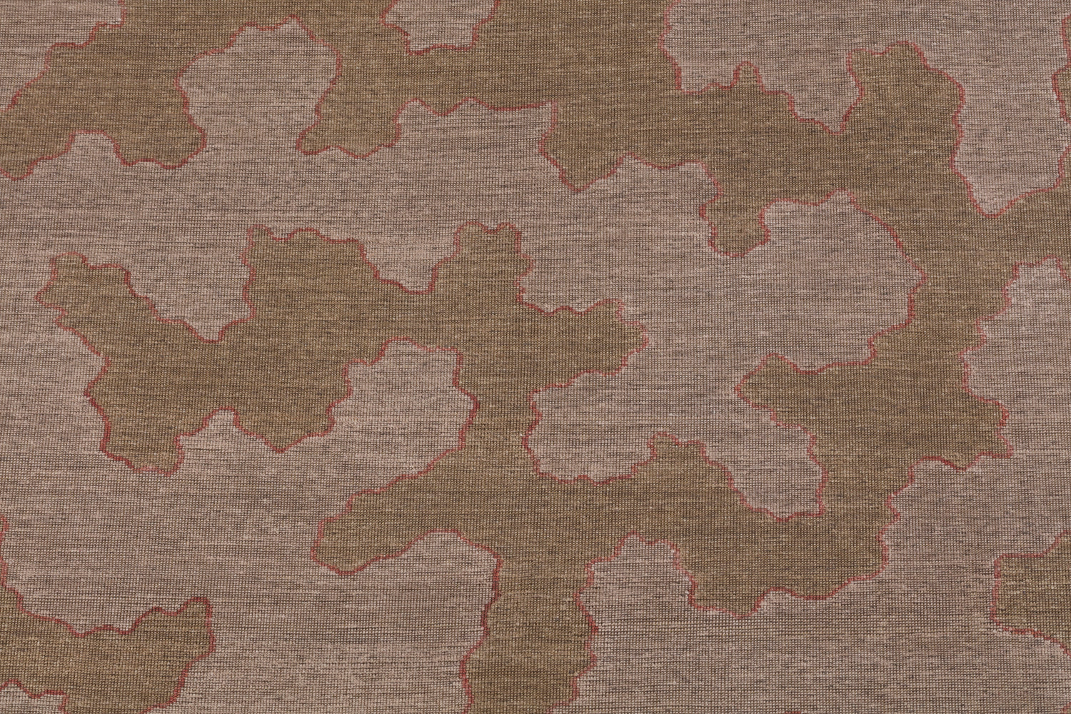 Detail of a handwoven rug in an abstract coral design brown and lavender with a pink accent line. 